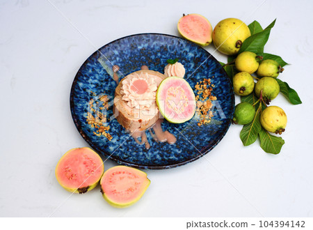 Guava Roll Cake on blue plate on light background with ripe guava fruit 104394142