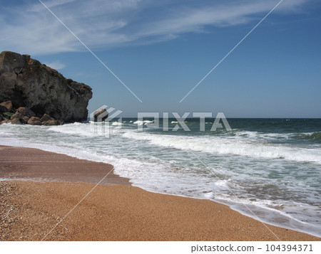 View of the rocky seashore. Fantastic view of the rocky shore on a sunny day with blue sky. A picturesque and magnificent scene. The concept of active recreation, travel. View of the rocky seashore. Fantastic view of the rocky shore on a sunny day with blue sky. A picturesque and magnificent scene. The concept of active recreation, travel. 104394371