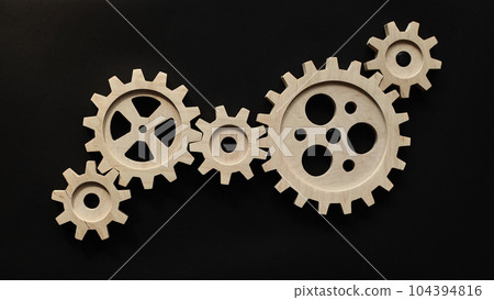 Wooden mechanisms on a black background. Black chalk board. 104394816