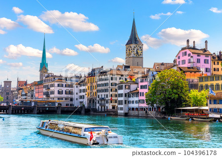 Ship is sailing by St. Peter's church and Fraum nster abbey, the two most popular places of visit in Zurich, Switzerland 104396178