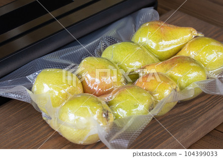 Packing fresh pears with a vacuum packer for long-term storage 104399033