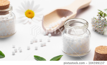 Composition of homeopathic medicines and medicinal plants on a white table Composition of homeopathic medicines and medicinal plants on a white table 104399137