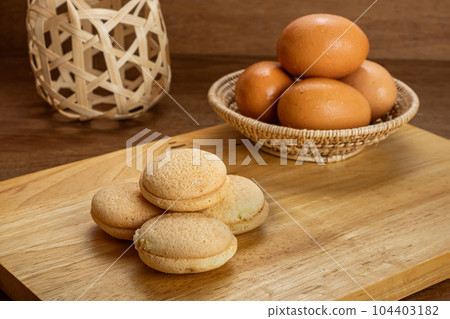 High angle view pile of small homemade sweet cake filled with pineapple jam on wooden board. 104403182