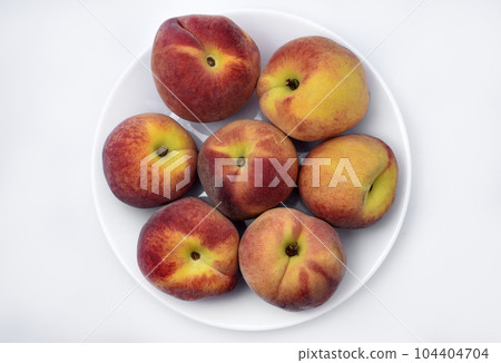 Juicy peaches on a white plate. Yellow-red large ripe peaches. Juicy fruits. Juicy peaches on a white plate. Yellow-red large ripe peaches. Juicy fruits. 104404704