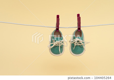 Children's sneakers hanging on a clothesline. Newborn concept Children's sneakers hanging on a clothesline. Newborn concept 104405264