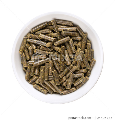 Vegan organic fertilizer pellets, in a white bowl. Naturally produced meadow clover fertilizer, to be added to soil or plants to provide nitrogen, phosphorus and potassium, and to sustain growth. 104406777