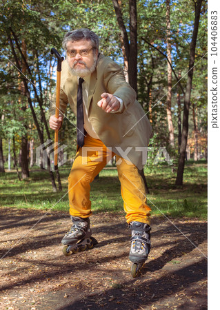 Funny old man on roller skates and walking stick. 104406883