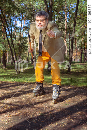 Funny old man on roller skates and walking stick. 104406885