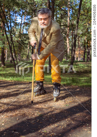 Funny old man on roller skates and walking stick. 104406886