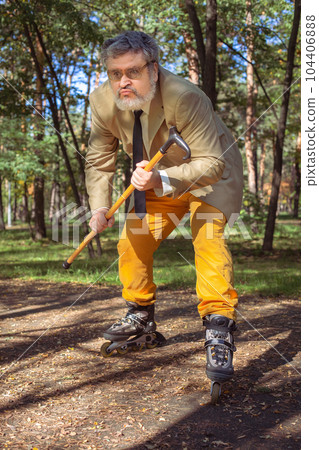 Funny old man on roller skates and walking stick. 104406888