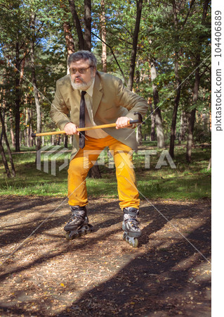 Funny old man on roller skates and walking stick. 104406889