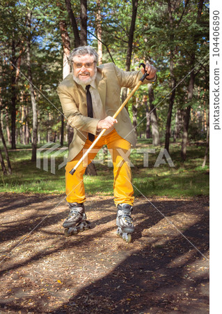 Funny old man on roller skates and walking stick. 104406890