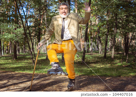 Funny old man on roller skates and walking stick. Funny old man on roller skates and walking stick. 104407016