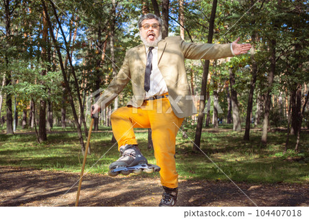 Funny old man on roller skates and walking stick. Funny old man on roller skates and walking stick. 104407018