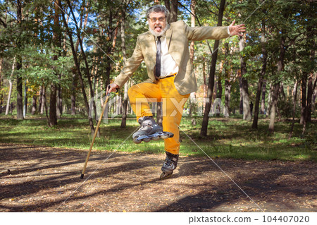 Funny old man on roller skates and walking stick. Funny old man on roller skates and walking stick. 104407020