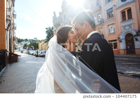 Bride and groom kisses tenderly in the shadow of a flying veil. Together. Wedding. Love. Bride and groom kisses tenderly in the shadow of a flying veil. Together. Wedding. Love. 104407175