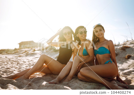 Three beautiful girls on the beach at sunset. Vacation time laughing and smiling. Three beautiful girls on the beach at sunset. Vacation time laughing and smiling. 104408274