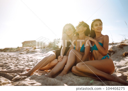Three beautiful girls on the beach at sunset. Vacation time laughing and smiling. Three beautiful girls on the beach at sunset. Vacation time laughing and smiling. 104408275