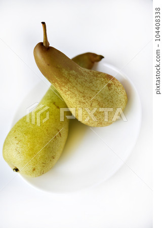 Fresh fruit. Green pear on a white plate. Chopped pear. Fresh fruit. Green pear on a white plate. Chopped pear. 104408338