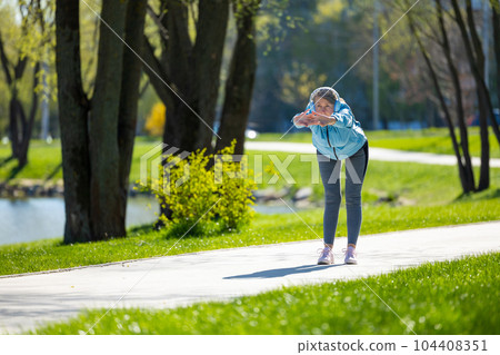 Woman in blue blazer doing leanings in the park Woman in blue blazer doing leanings in the park 104408351
