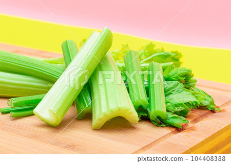 Fresh Celery Stem and Chopped Celery Sticks on Wooden Cutting Board Fresh Celery Stem and Chopped Celery Sticks on Wooden Cutting Board 104408388