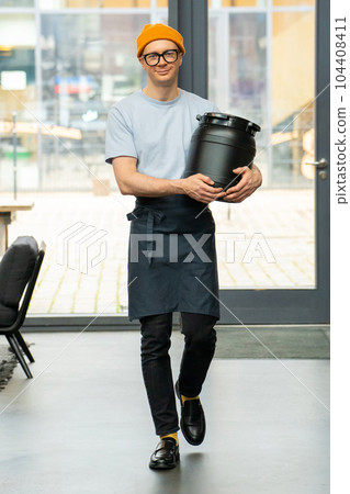 Barista carrying barrel preparing for work in coffee shop. 104408411