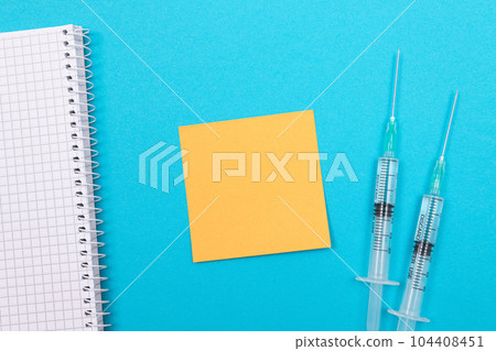 Vaccination or Revaccination Concept - Two Medical Syringe on Blue Table 104408451