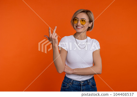 Smiling woman in white t shirt and jeans showing three fingers Smiling woman in white t shirt and jeans showing three fingers 104408537