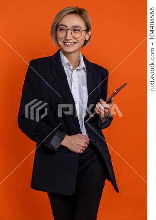 Delighted woman wearing black official style suit with tablet in hands Delighted woman wearing black official style suit with tablet in hands 104408566