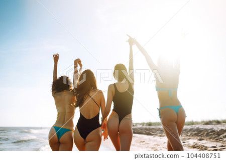 Four young girls having fun on the beach. Group of girlfriends enjoying on beach holiday. Summer lifestyle. Four young girls having fun on the beach. Group of girlfriends enjoying on beach holiday. Summer lifestyle. 104408751