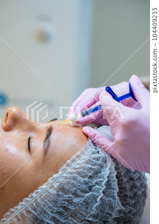 Face injections to woman with skin problems, beauty treatment in cosmetology clinic. Face injections to woman with skin problems, beauty treatment in cosmetology clinic. 104409215
