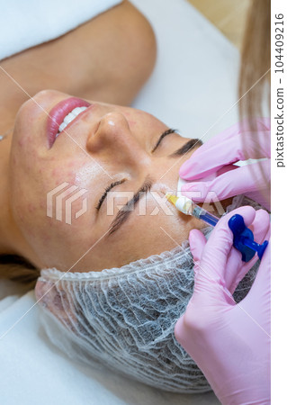 Cosmetologist doing PRP ttherapy in beauty clinic, making injection. 104409216