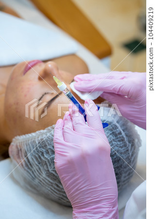 Cosmetologist doing injections to woman's face, skin treatment. Cosmetologist doing injections to woman's face, skin treatment. 104409219