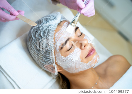Cosmetologist doing cleansing beauty procedures in clinic, peeling and anti aging. 104409277