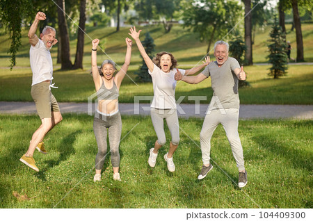 Group of healthy runners team jumping in the air at city park during morning training. Group of healthy runners team jumping in the air at city park during morning training. 104409300