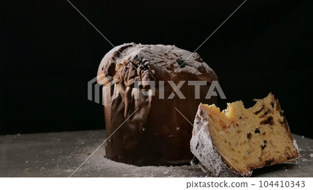 Panettone with dried fruits on black background, selective focus. Panettone with dried fruits on black background, selective focus. 104410343