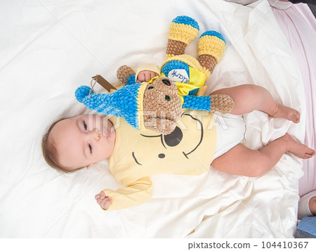 Cute newborn baby lying with a teddy bear Cute newborn baby lying with a teddy bear 104410367