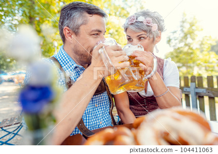 Mature couple drinking in beer garden 104411063