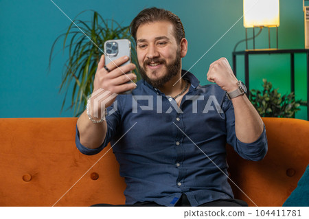 Lebanese man use smartphone celebrating winning, lottery jackpot goal achievemen, good news, victory 104411781