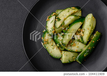 Delicious juicy cucumber cut into large slices with salt, spices and french mustard 104411909