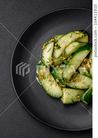 Delicious juicy cucumber cut into large slices with salt, spices and french mustard 104411910