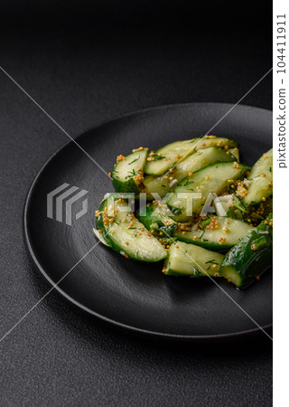 Delicious juicy cucumber cut into large slices with salt, spices and french mustard 104411911