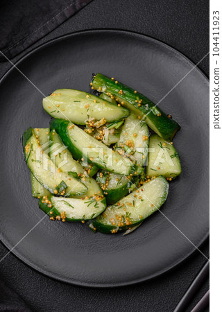 Delicious juicy cucumber cut into large slices with salt, spices and french mustard Delicious juicy cucumber cut into large slices with salt, spices and french mustard 104411923