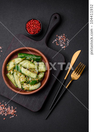 Delicious juicy cucumber cut into large slices with salt, spices and french mustard Delicious juicy cucumber cut into large slices with salt, spices and french mustard 104411932