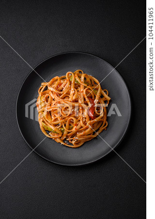 Delicious asian udon dish with vegetables, mushrooms, salt and spices 104411965