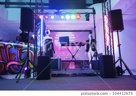 Dj controller on stage for discotheque in empty nightclub with no people. Electronic musician console equipment, loudspeakers and spotlights for live music concert in dark club. 104412673