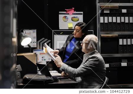 Business management coworking executives checking accountancy market database. Analysis paperwork in archival file room filled with cabinet, folders and graphic charts 104412729
