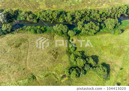 The confluence of a small stream into the river, aerial view. Giblitsa stream flowing into the Luzha river, Kaluga region The confluence of a small stream into the river, aerial view. Giblitsa stream flowing into the Luzha river, Kaluga region 104413020