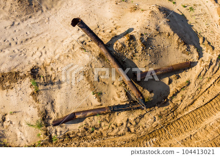 Old rusty pipes from a dredger on a sand pit, top view Old rusty pipes from a dredger on a sand pit, top view 104413021
