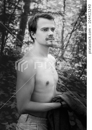 Black and white portrait handsome sexy man, athlete with perfect slender naked body standing three-quarters to the camera holding hand at neck, looking at camera in park. Man posing outdoors. High Black and white portrait handsome sexy man, athlete with perfect slender naked body standing three-quarters to the camera holding hand at neck, looking at camera in park. Man posing outdoors. High 104413240